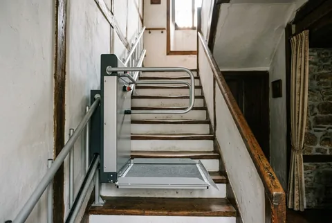 Salvaescaleras de pie con plataforma y asidero en una escalera estrecha